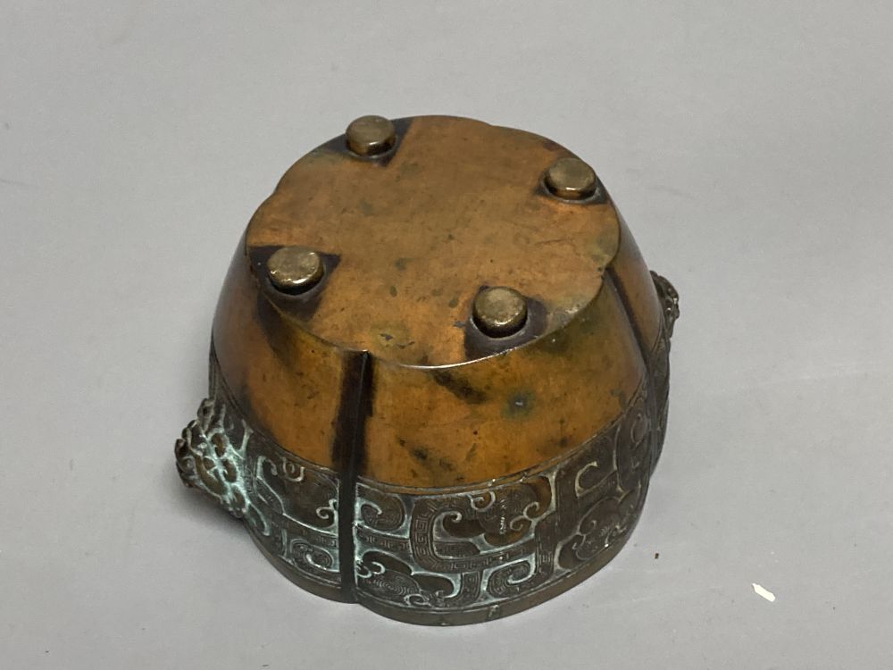 A Chinese bronze lobed censer, 18th century, archaistic cast band, on four disc feet, 11cm diameter